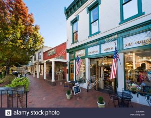 A photopgrah of the picnic cafe, located in the dahlonega square. Small picnic tables and a chalkboard sign sit out the front, with large american flags hanging from the store front.